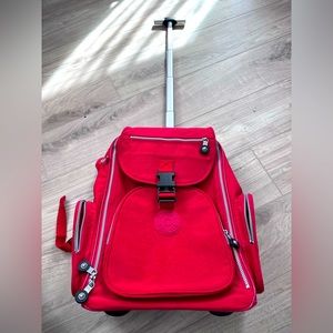 Red Kipling suitcase that can turn into a backpack and has a little red bag